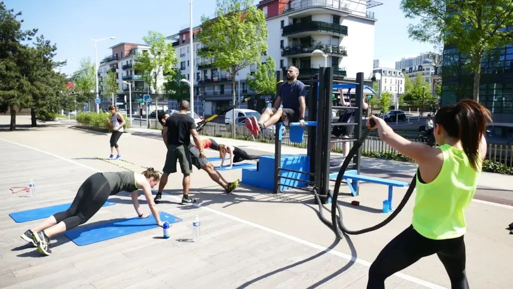 Un groupe de personnes pratiquant du sport en plein air dans un parc urbain.