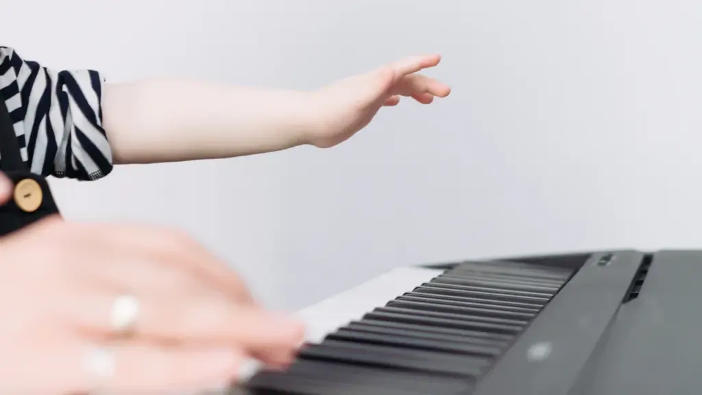 Mains d'un enfant et d'un adulte jouant ensemble sur un clavier de piano