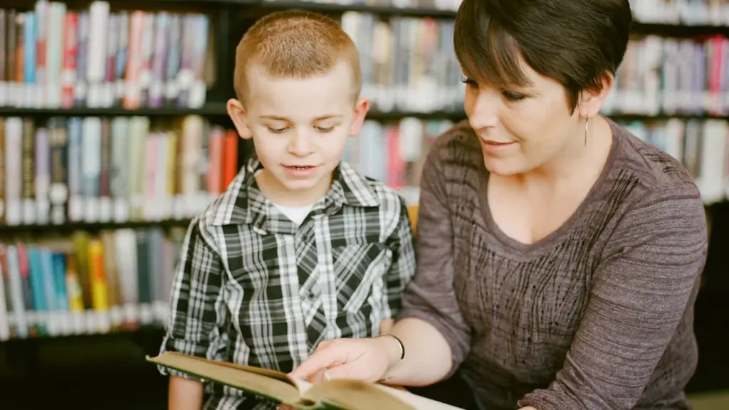 Une mère lit un livre à son jeune fils dans une bibliothèque.