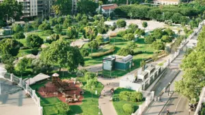 Vue aérienne d'un parc urbain verdoyant entouré de bâtiments en centre-ville.