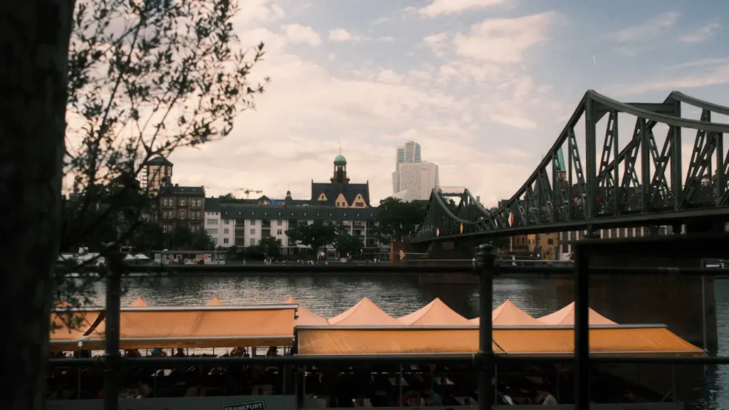 Vue panoramique sur une rivière urbaine, un pont et des bateaux à quai.