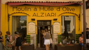 Façade jaune traditionnelle d'une boutique artisanale française avec des clients devant.