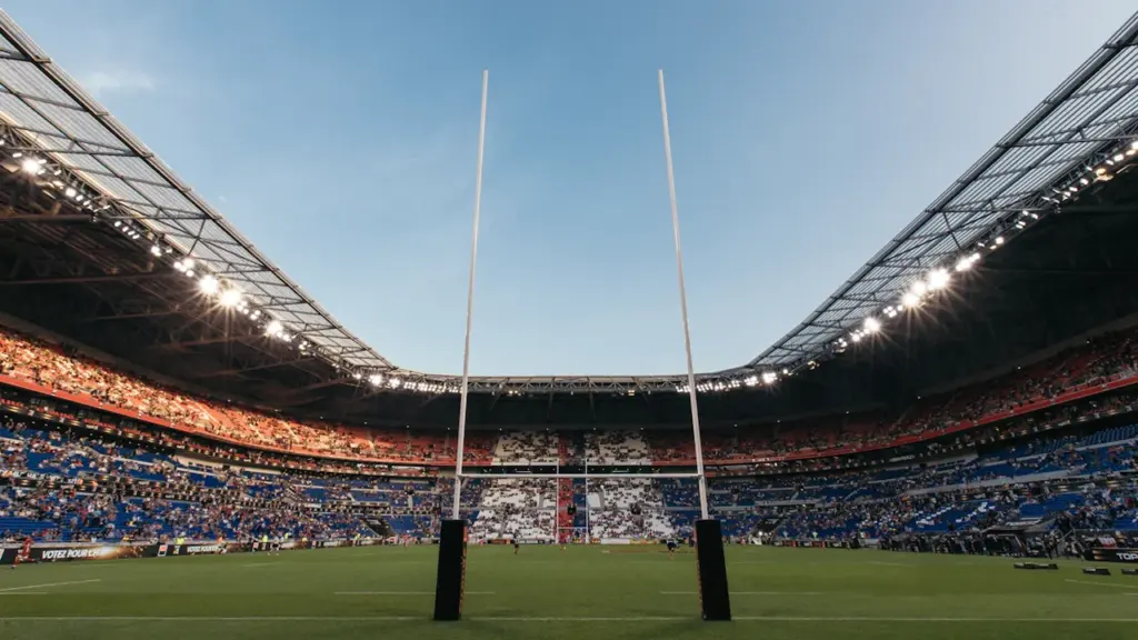 Vue du terrain et des poteaux de rugby dans un stade en France.