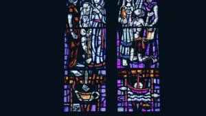 Vitraux colorés détaillés illustrant des scènes religieuses au sein d'une église historique.