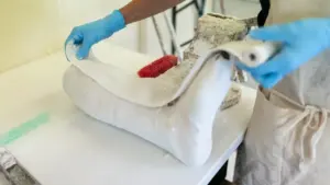 Un technicien prépare un moulage médical sur mesure dans un atelier spécialisé.