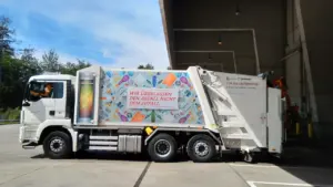 Un camion benne de ramassage des déchets garé devant un bâtiment technique municipal.