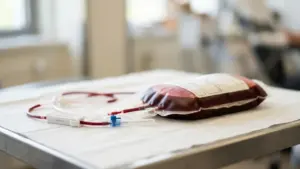 Une poche de sang médical avec ses tubulures posée sur une table en hôpital.