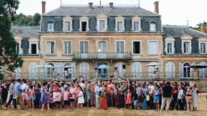 Une large foule devant un château français lors d'un événement culturel estival.
