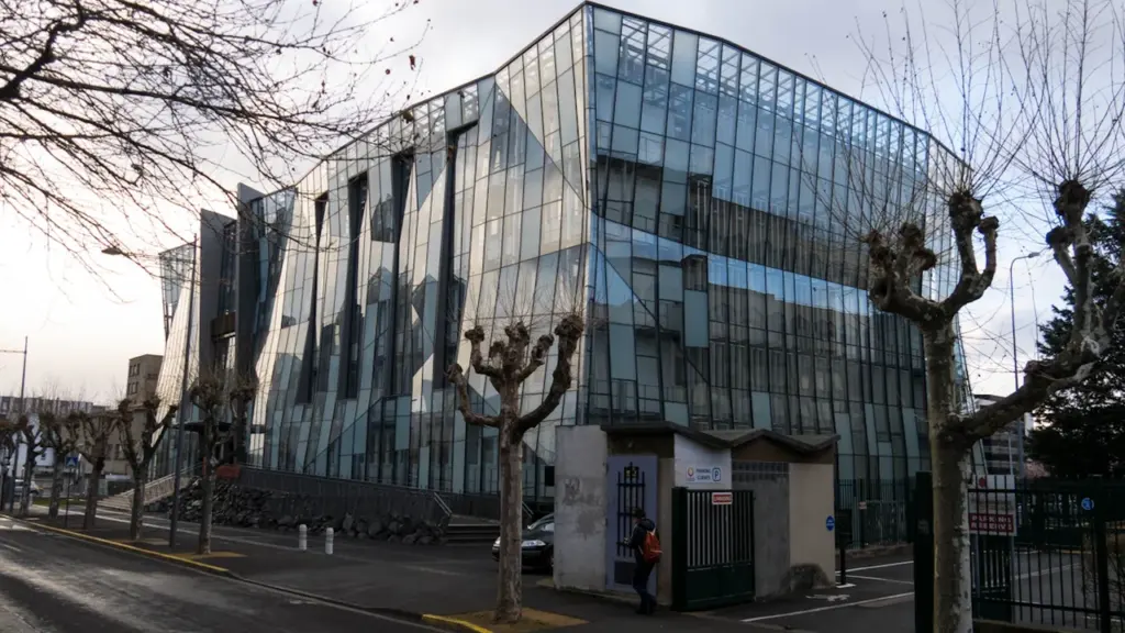 Grand bâtiment vitré moderne situé le long d'une rue à Clermont-Ferrand en France.