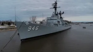 Un grand navire de guerre ancré dans un port maritime historique.