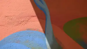 Détail artistique d'une peinture murale colorée représentant des formes marines abstraites et ombrées.
