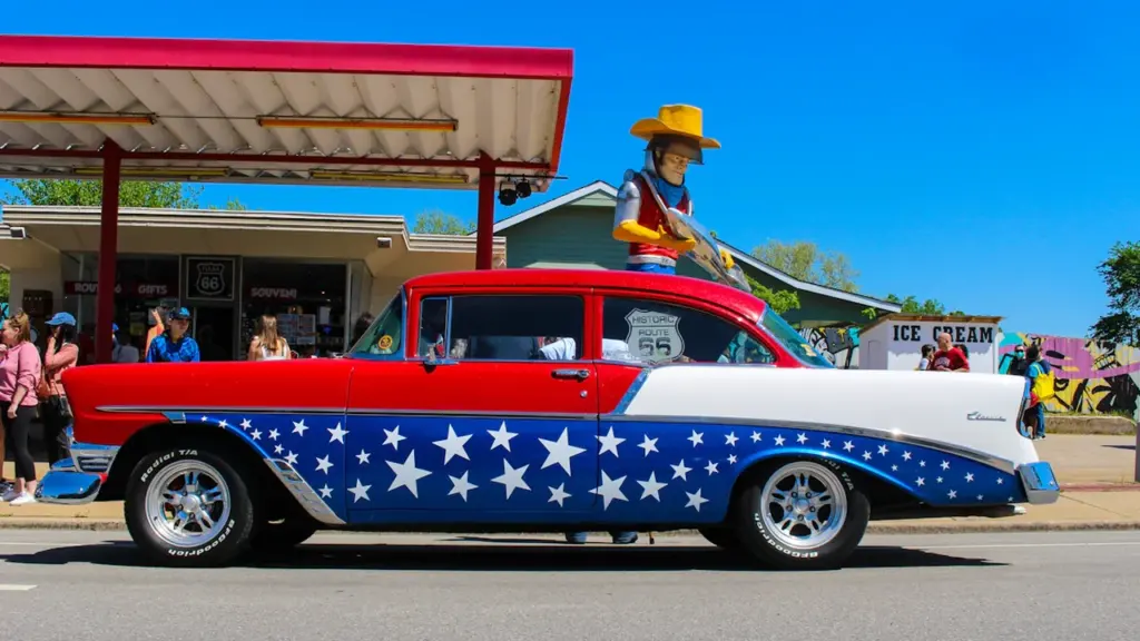 Voiture américaine classique décorée aux couleurs des États-Unis devant un bâtiment.
