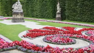 Une statue classique dans un jardin paysager fleuri en France.
