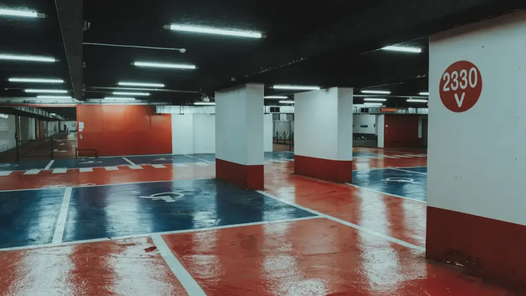Vue d'un parking souterrain moderne avec marquages au sol rouges et blancs à Grenoble.