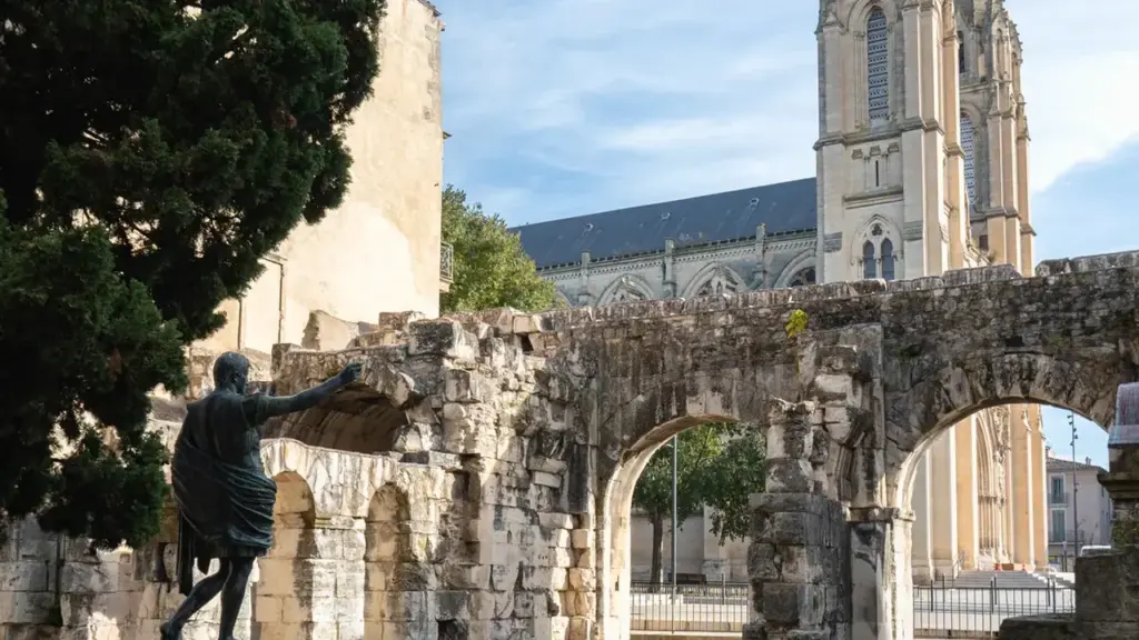 Une statue en bronze dans les ruines antiques avec une église gothique en arrière-plan.