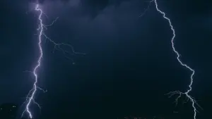 Un éclair spectaculaire illumine le ciel nocturne au-dessus d'une ville française.