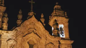 Façade d'une église baroque richement détaillée et illuminée pendant la nuit